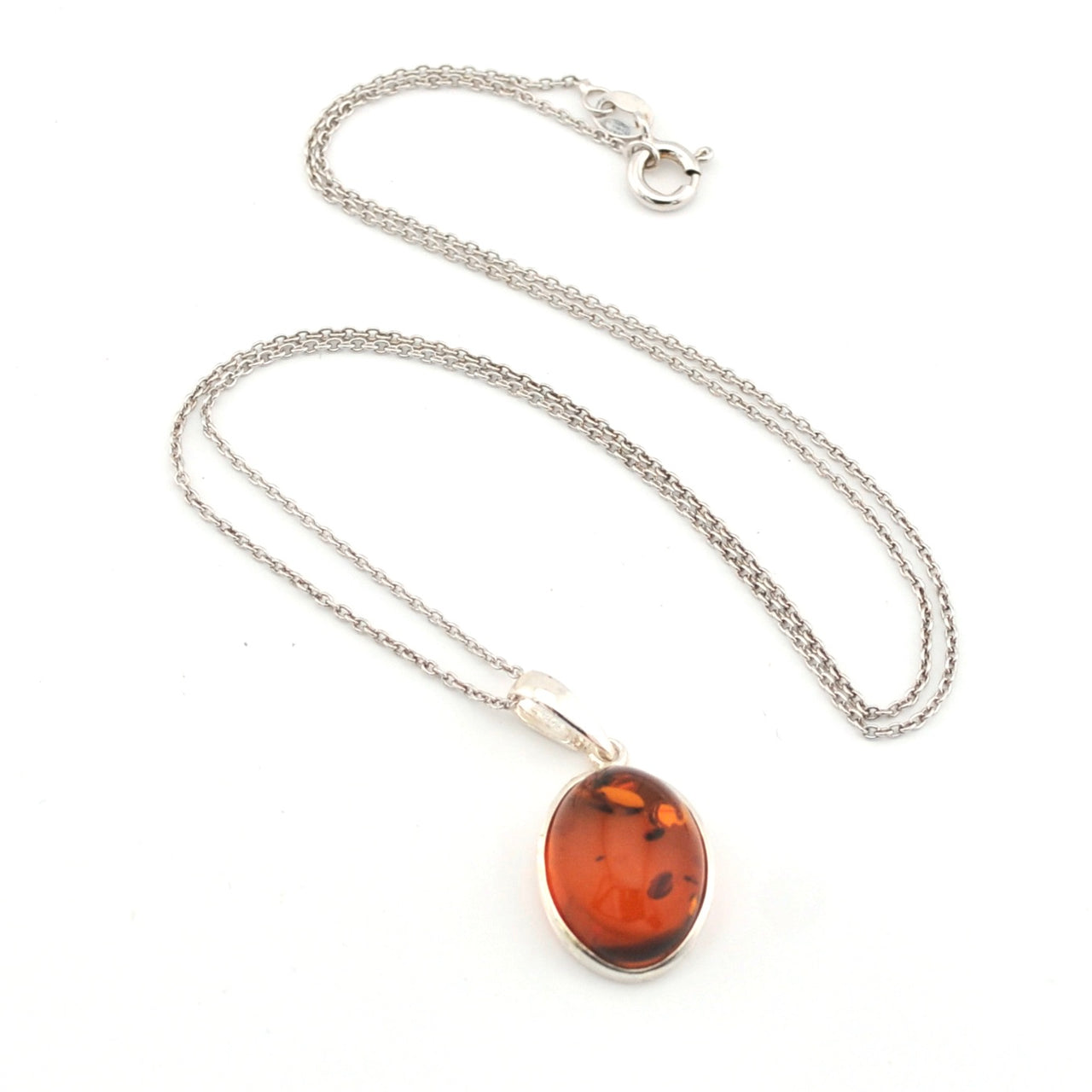 Silver necklace with an amber pendant on a white background