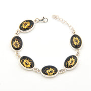 Bracelet with black and gold sunflower designs on a white background