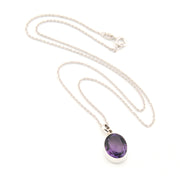 Silver necklace with a purple pendant on a white background