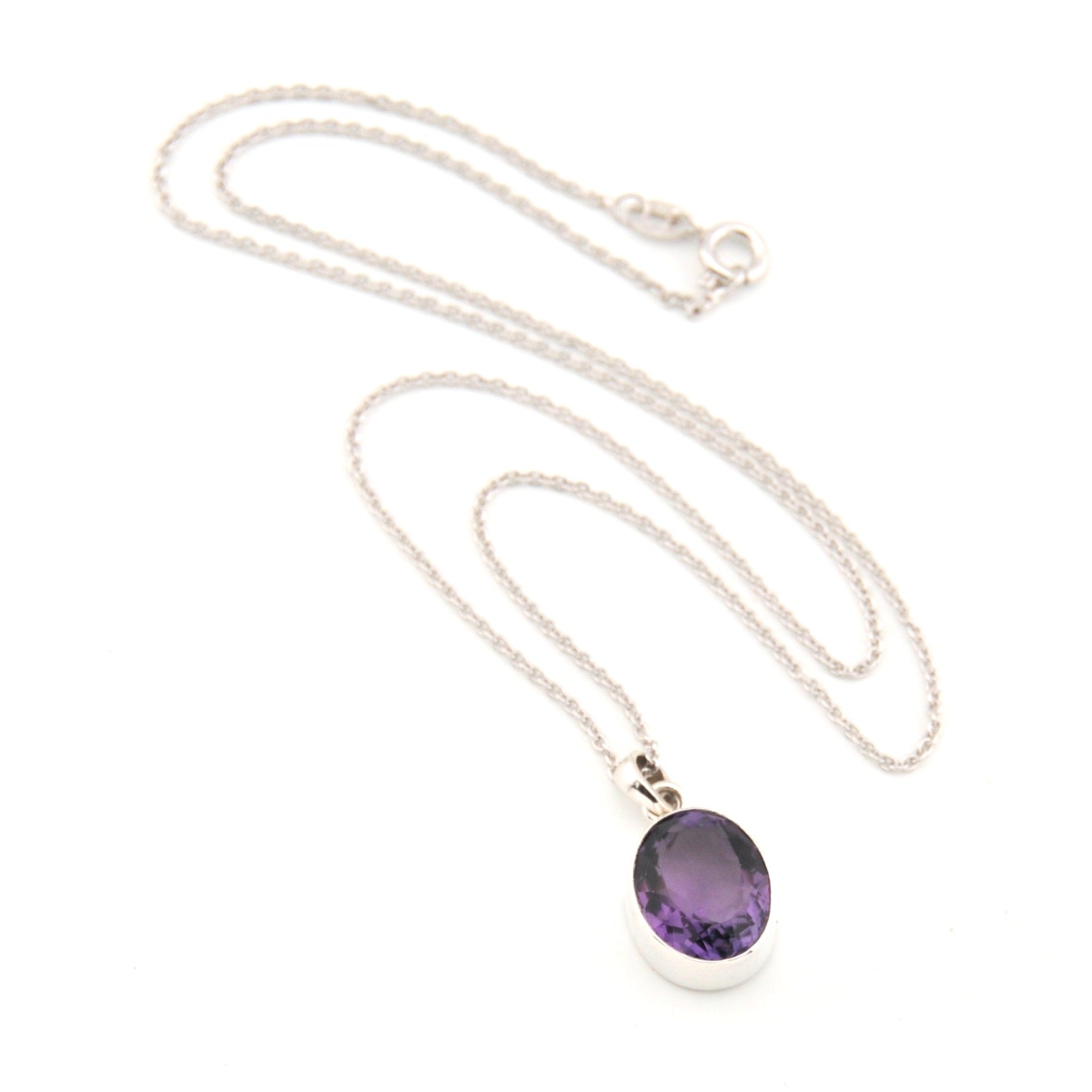Silver necklace with a purple pendant on a white background
