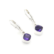 Silver earrings with purple gemstones on a white background
