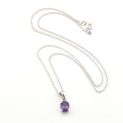 Silver necklace with a purple gemstone pendant on a white background
