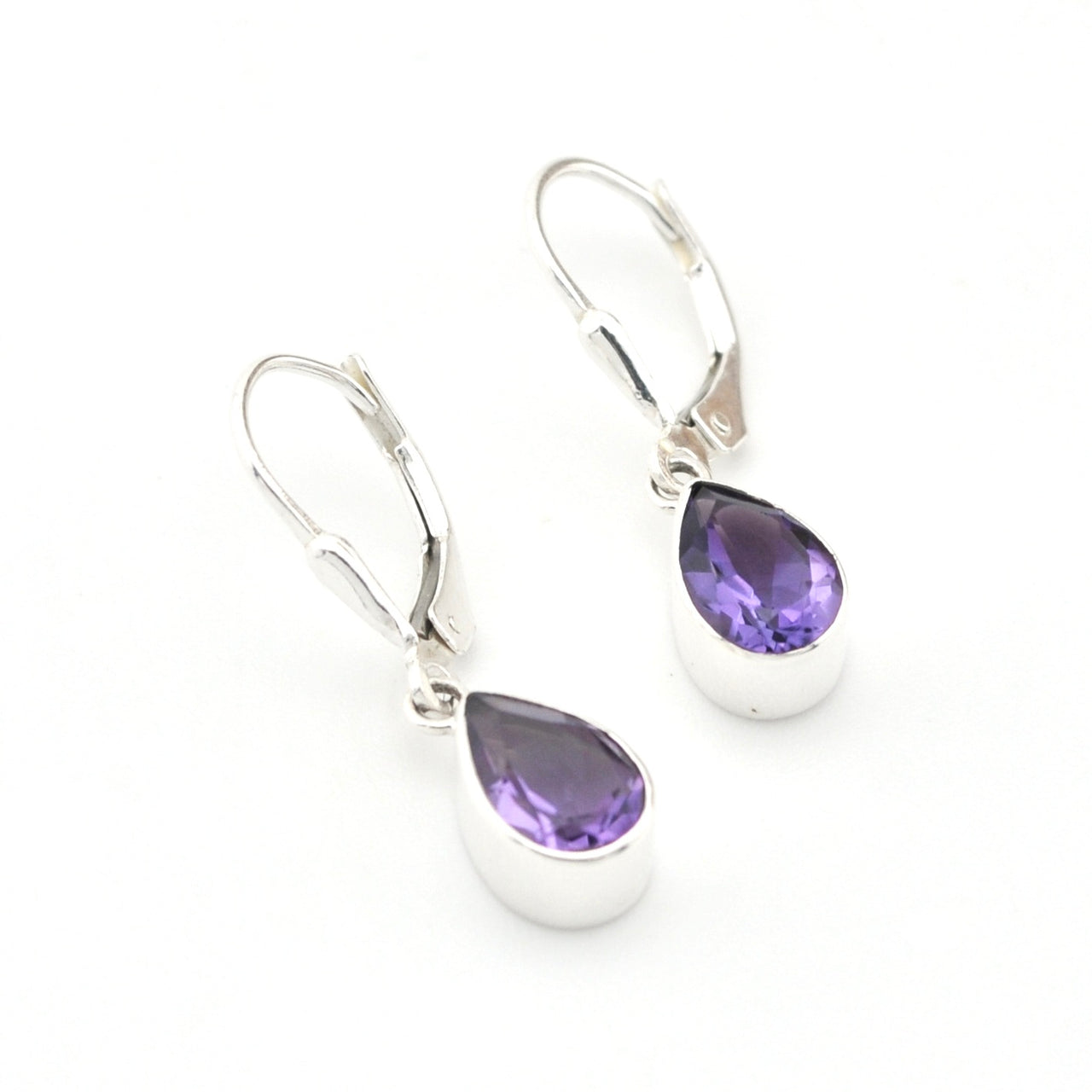 Silver earrings with purple teardrop-shaped gemstones on a white background