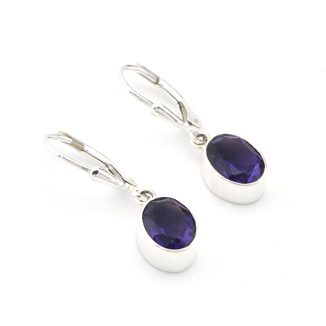 Silver earrings with purple gemstones on a white background