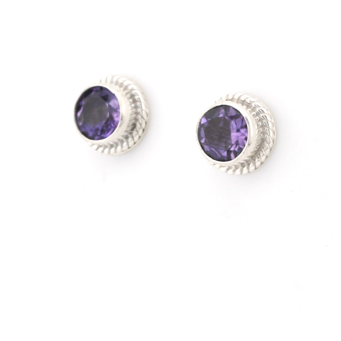 Pair of silver earrings with purple gemstones on a white background