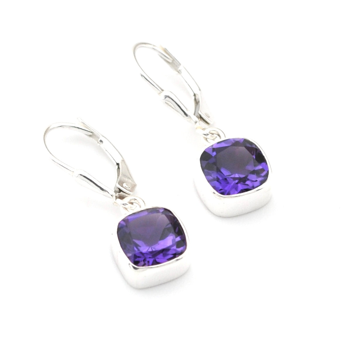 Silver earrings with purple gemstones on a white background