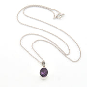 Silver necklace with a purple pendant on a white background