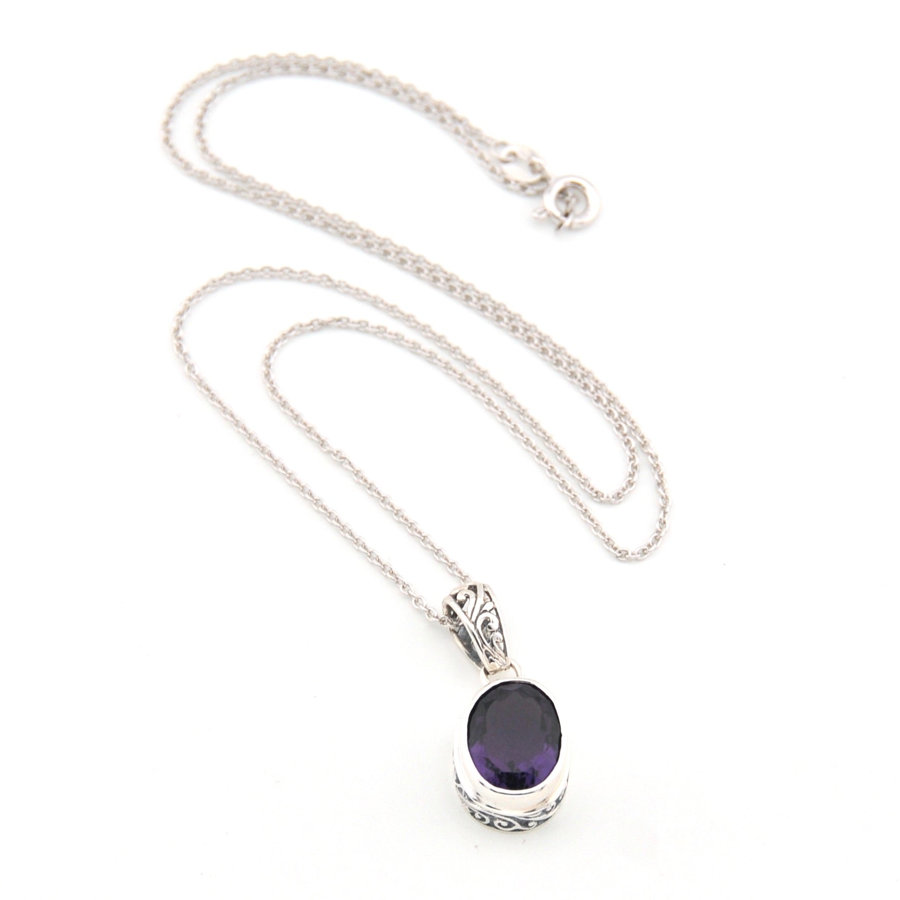 Silver necklace with a purple gemstone pendant on a white background