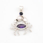 Silver crab pendant with purple gemstone on a white background
