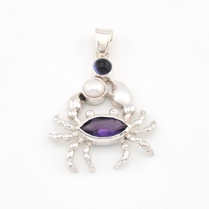 Silver crab pendant with purple gemstone on a white background