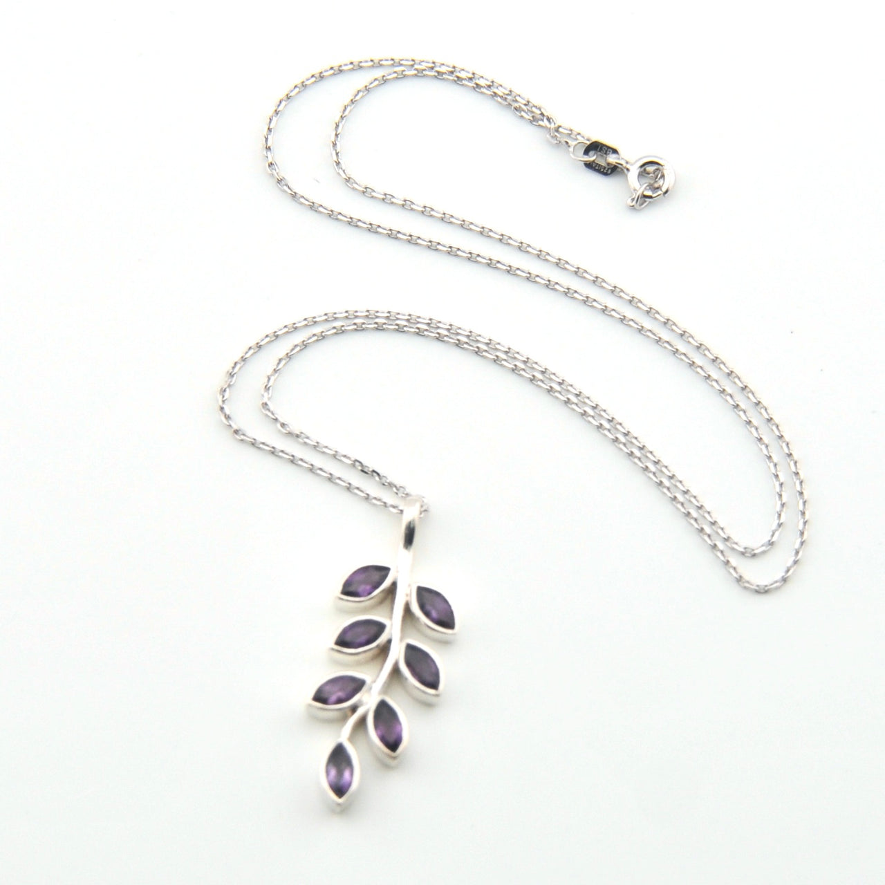 Silver necklace with a leaf-shaped pendant on a white background
