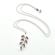 Silver necklace with a leaf-shaped pendant on a white background