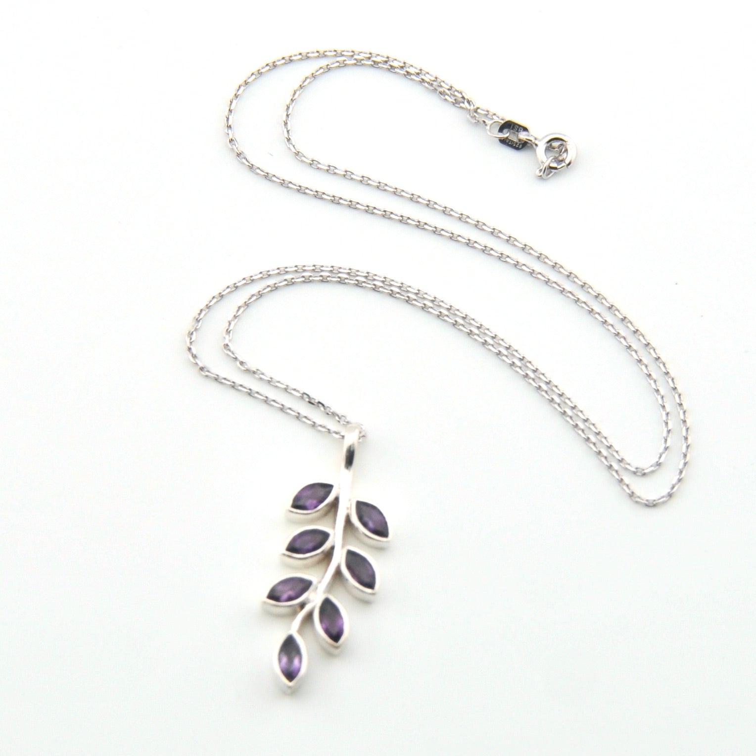 Silver necklace with a leaf-shaped pendant on a white background