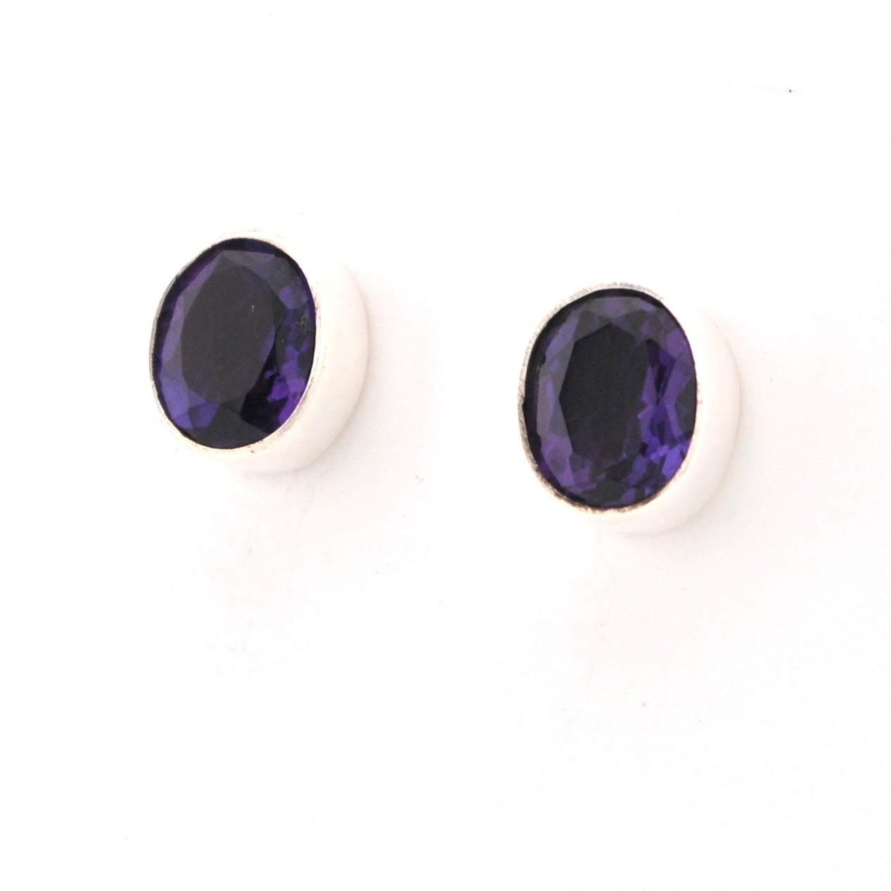Pair of purple gemstone earrings on a white background
