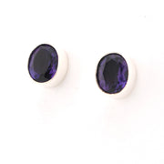 Pair of purple gemstone earrings on a white background