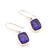 Silver earrings with purple gemstones on a white background