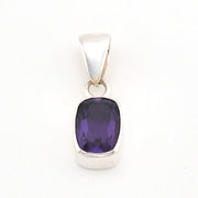Silver pendant with a purple gemstone on a white background