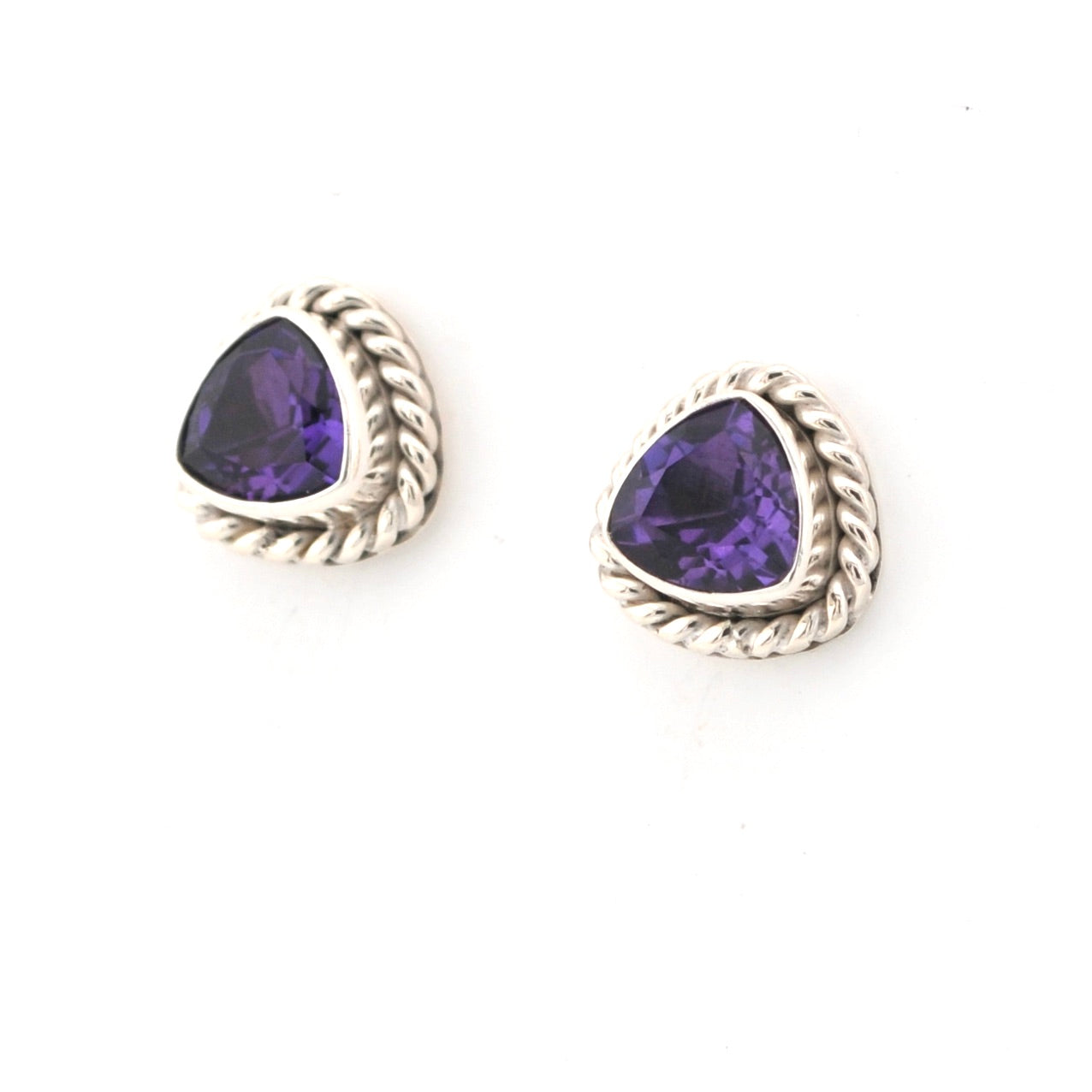 Pair of silver earrings with purple gemstones on a white background