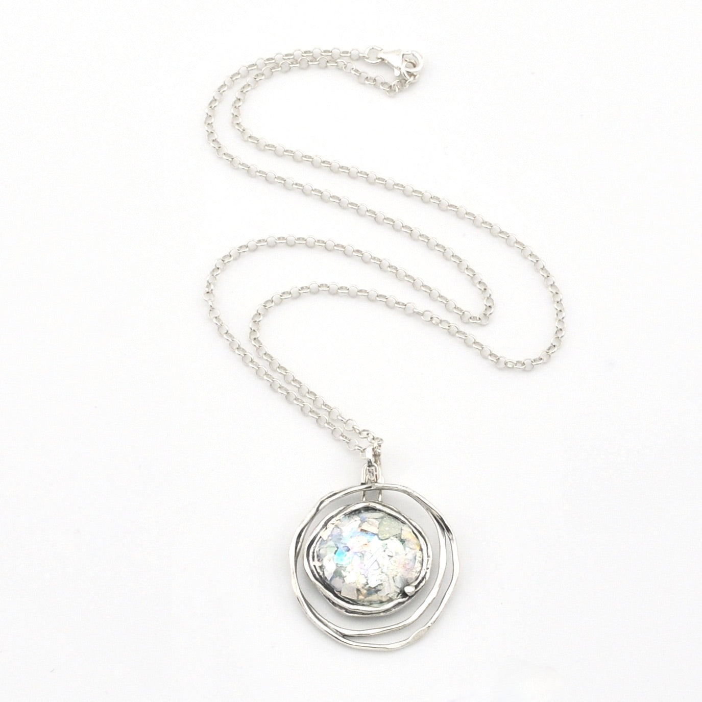 Silver necklace with a round pendant on a white background