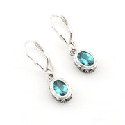 Silver earrings with blue gemstones on a white background