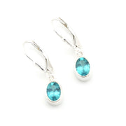 Silver earrings with blue gemstones on a white background