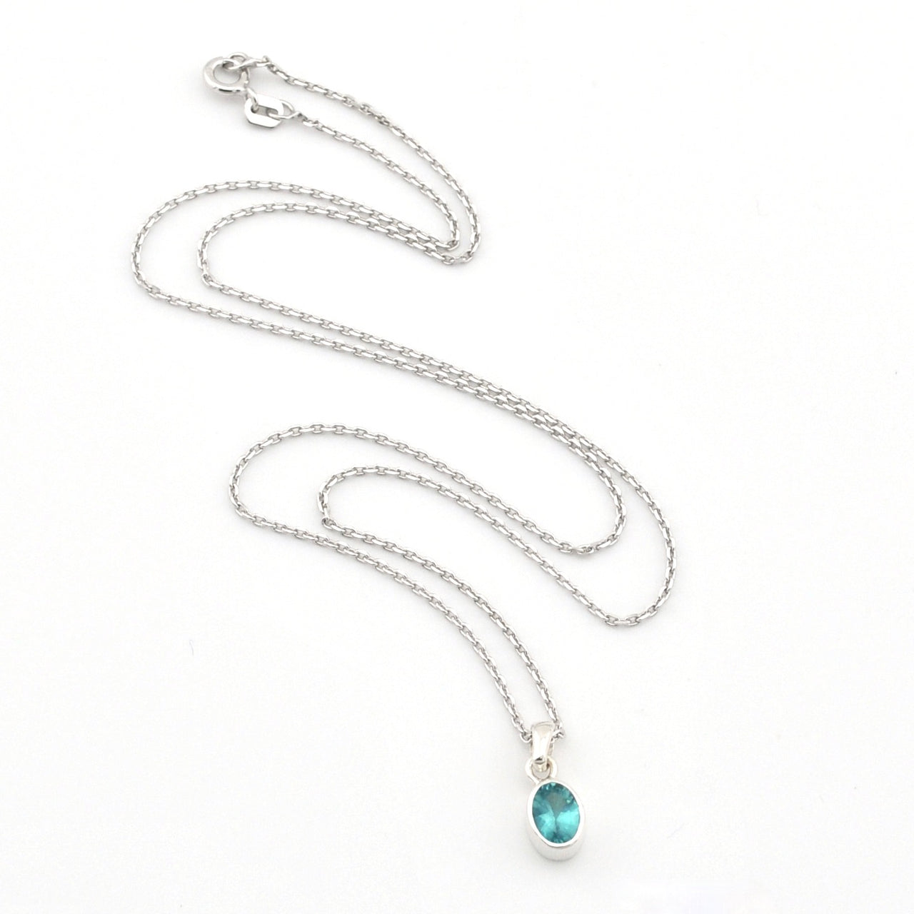 Silver necklace with a blue pendant on a white background