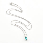 Silver necklace with a blue pendant on a white background