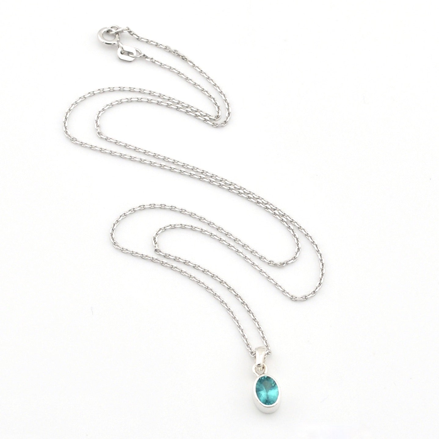 Silver necklace with a blue pendant on a white background