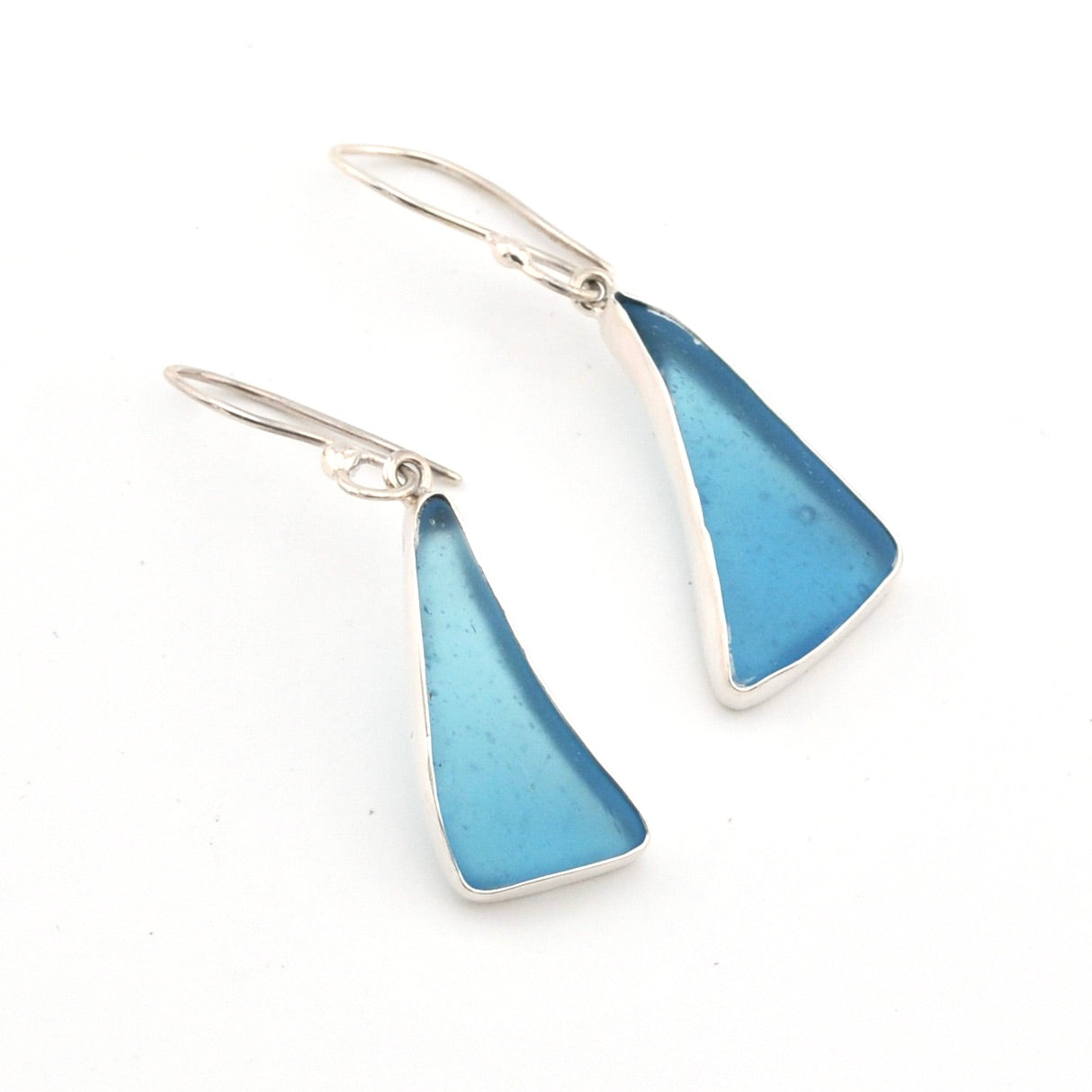 Pair of blue triangular earrings with silver hooks on a white background