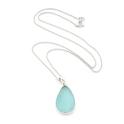Teardrop-shaped light blue pendant on a silver chain against a white background
