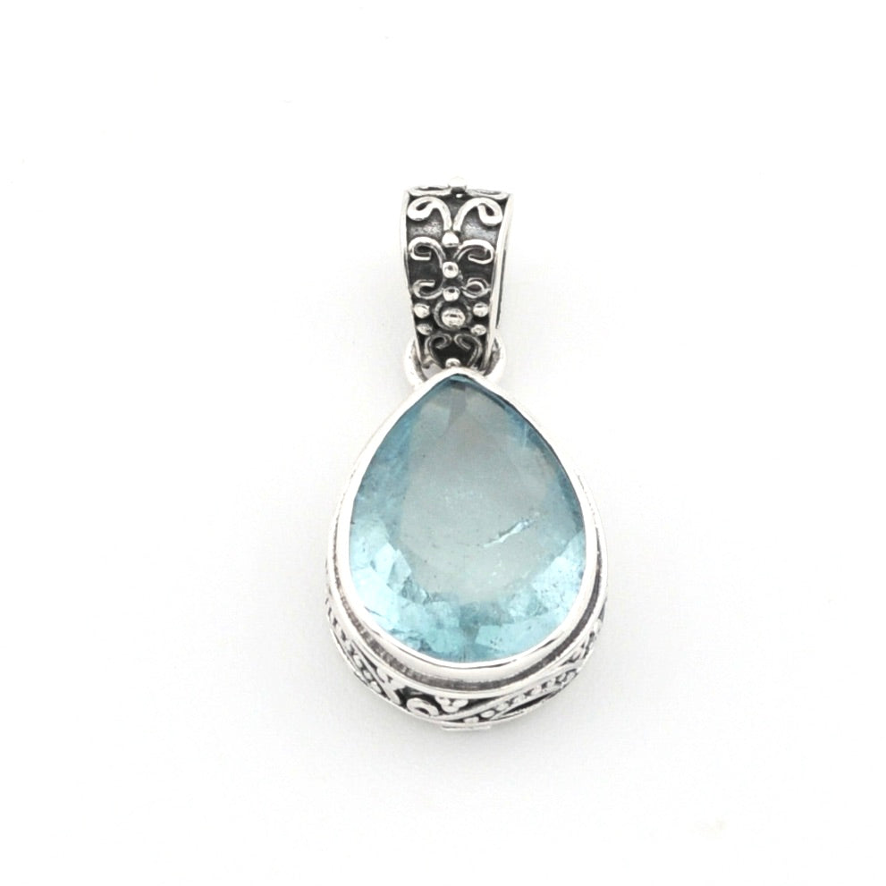 Teardrop-shaped blue gemstone pendant with silver setting on a white background