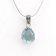 Teardrop-shaped blue gemstone pendant on a white background