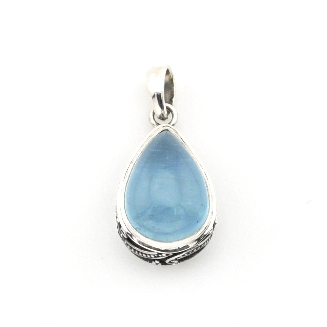 Teardrop-shaped blue pendant with silver frame on a white background