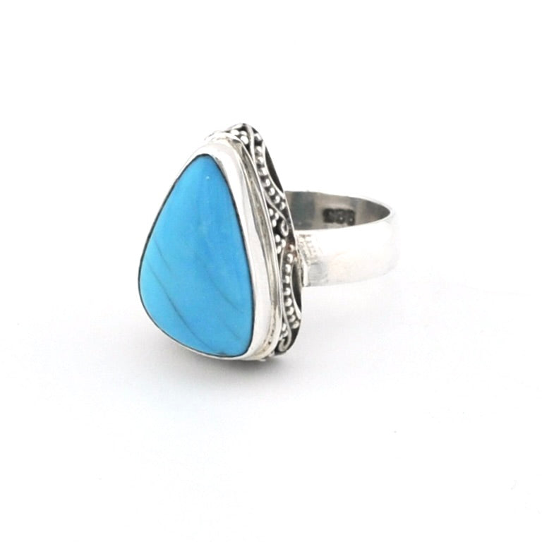 Turquoise triangular ring with sterling silver on white background.