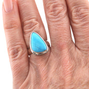 Silver turquoise ring on finger.