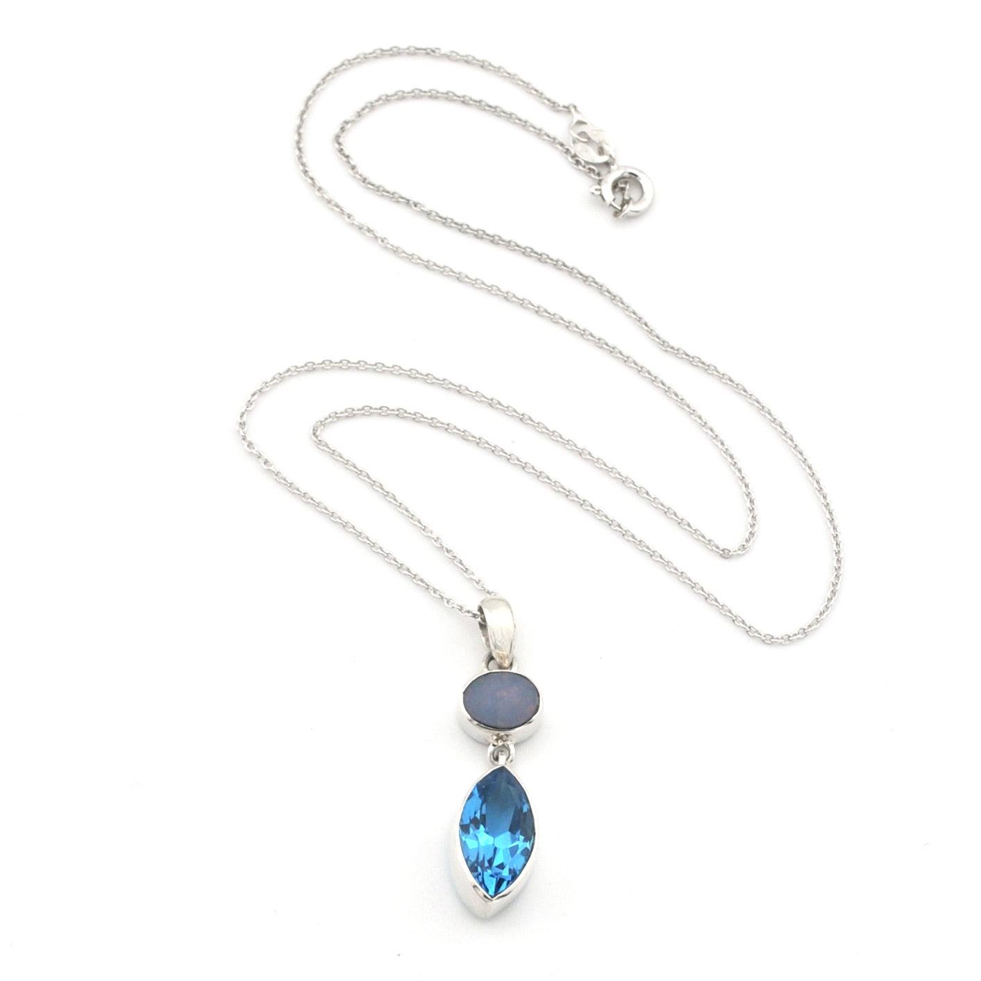A silver necklace featuring a marquise-cut blue topaz pendant and a small oval opal stone, displayed on a clean white background.