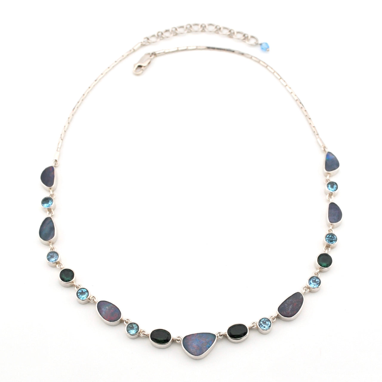 Necklace with opal, blue topaz, green quartz on a white background