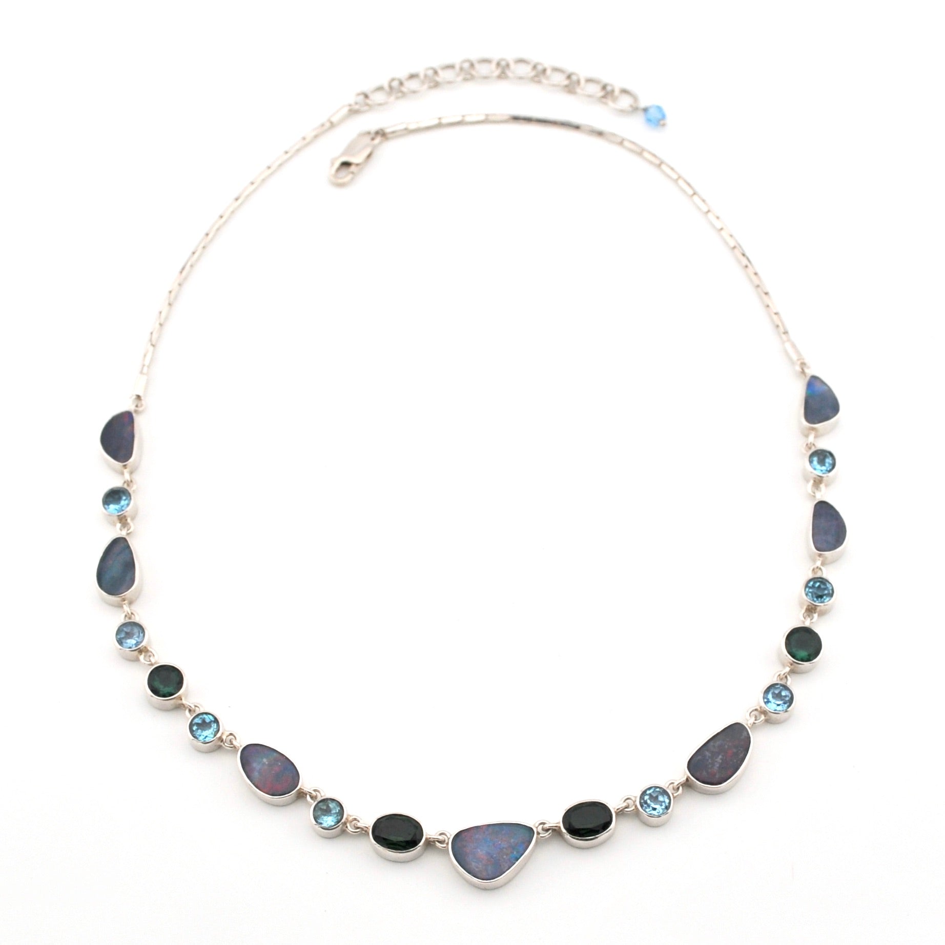 Necklace with opal, blue topaz, green quartz on a white background