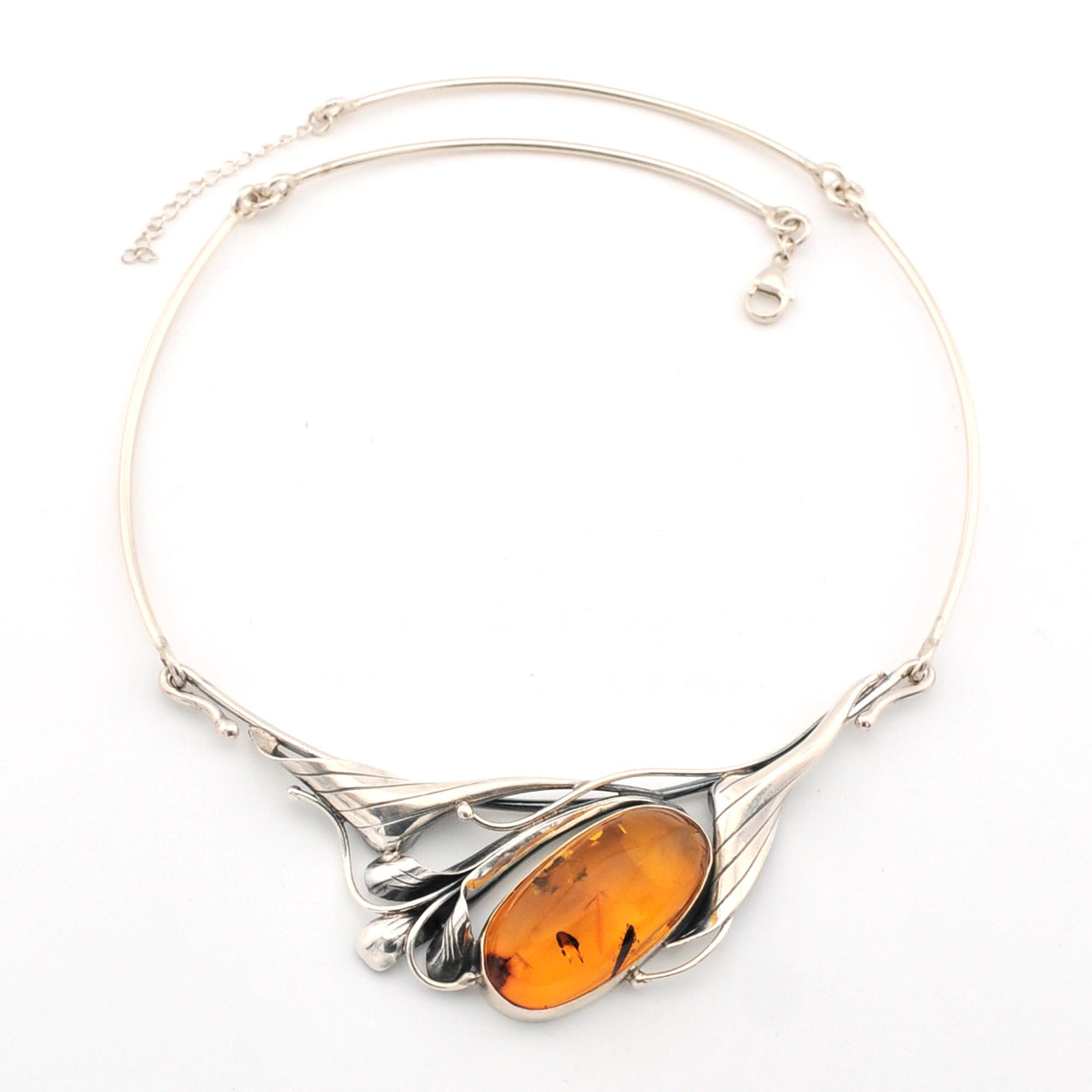 Silver necklace with an amber pendant on a white background