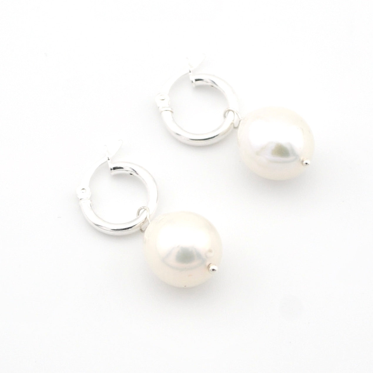 Pair of pearl hoop earrings on a white background