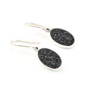 Black stone earrings with silver hooks on a white background