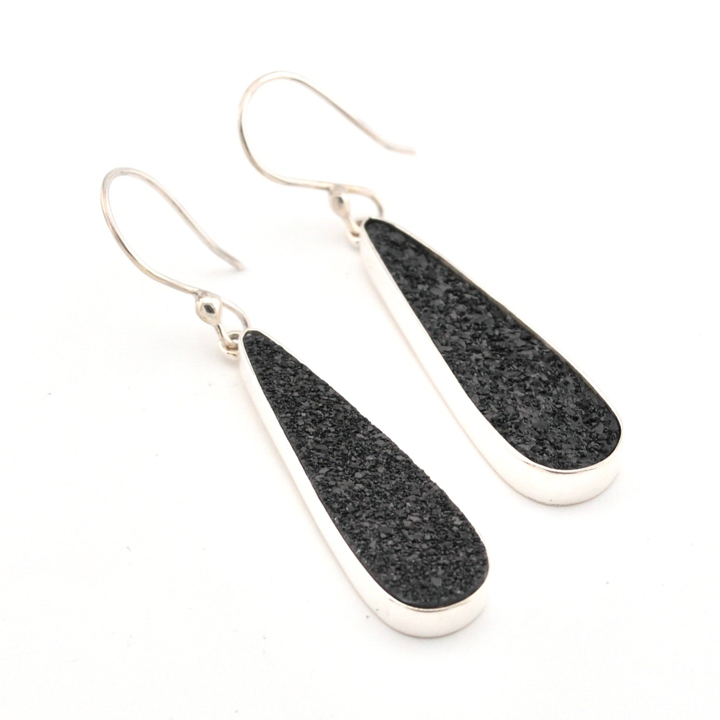 Black teardrop earrings with silver hooks on a white background