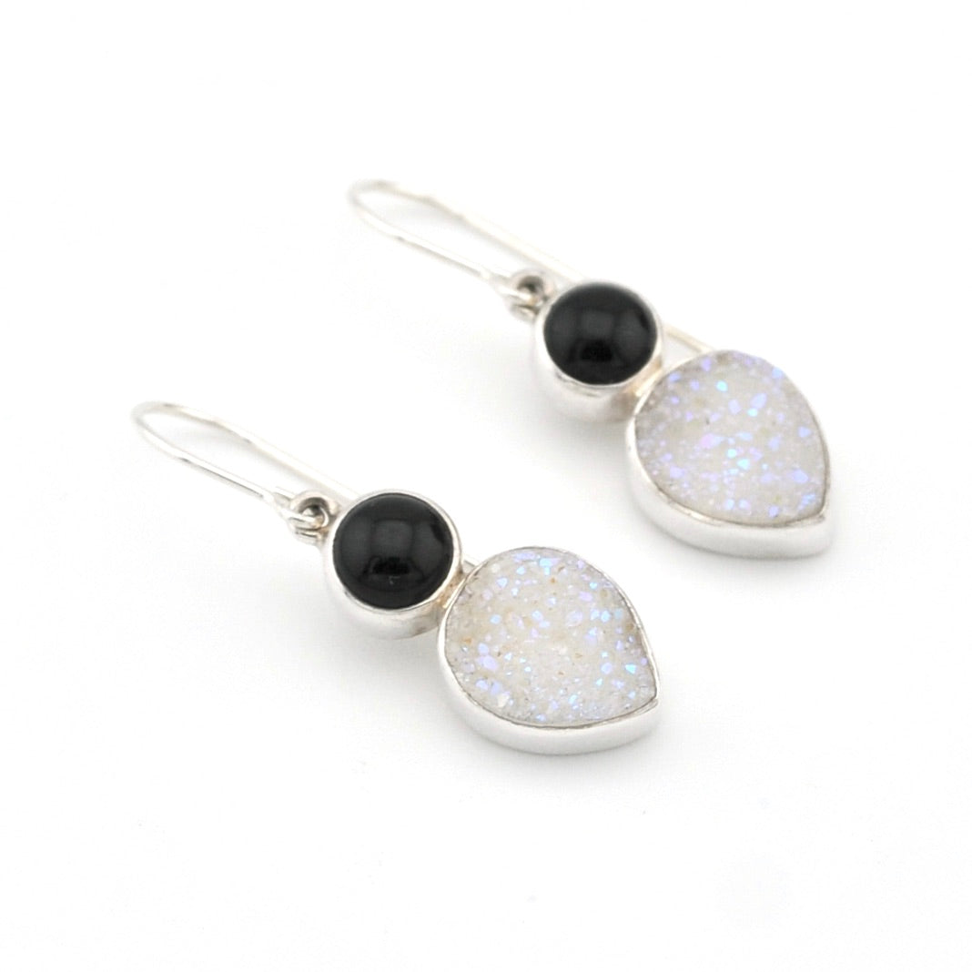 Pair of earrings with black and white stones on a white background