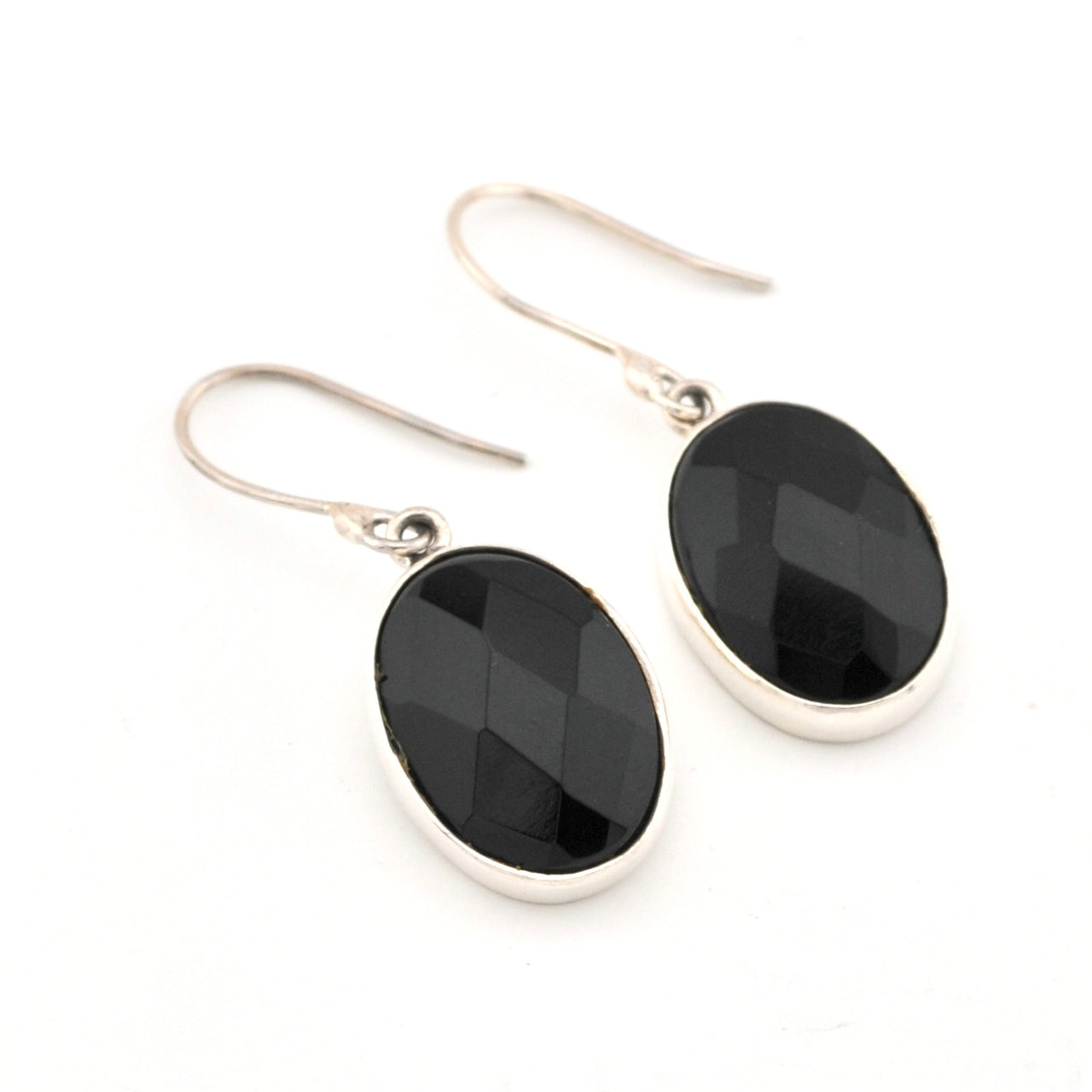 Black oval stone earrings with silver hooks on a white background