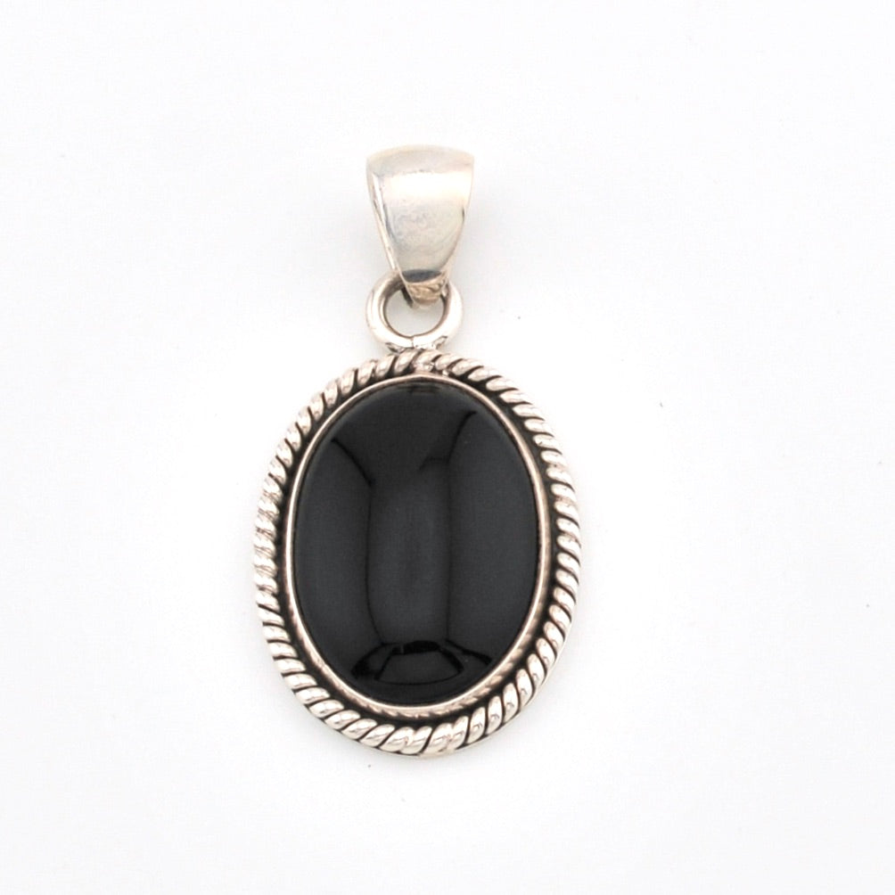 Silver pendant with a black stone on a white background