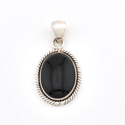 Silver pendant with a black stone on a white background