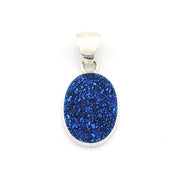 An oval pendant featuring a vibrant blue glittery druzy stone in a silver bezel setting with a silver bail, shown on a plain white background.