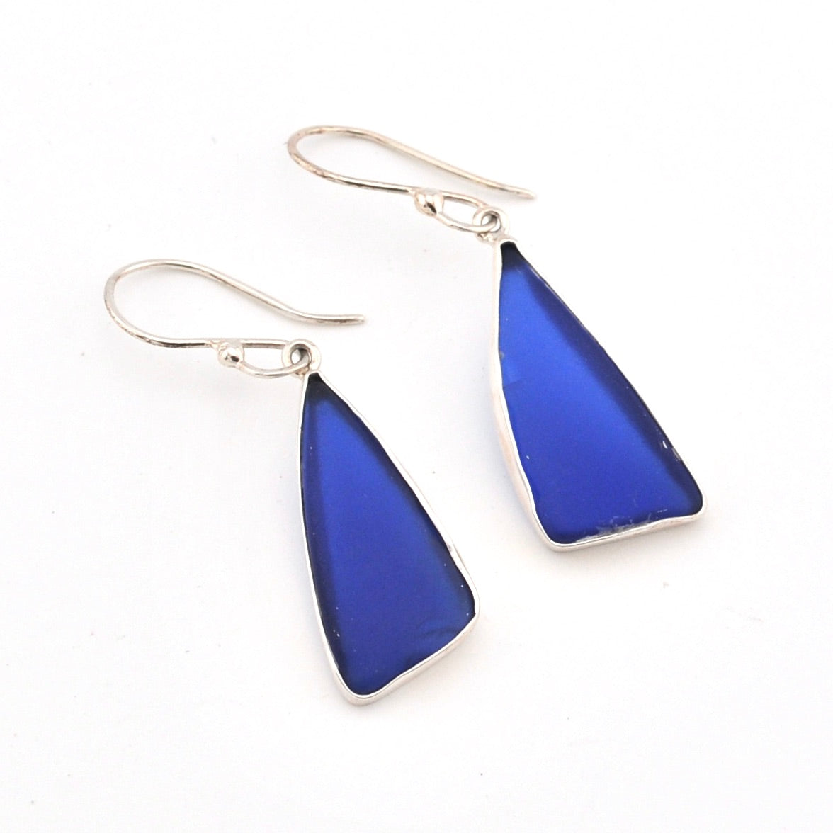 Blue teardrop earrings with silver hooks on a white background
