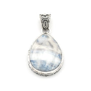 A sterling silver pendant featuring a teardrop-shaped scheelite gemstone with natural white and light blue marbling, set in an ornate silver bezel with a decorative bail.