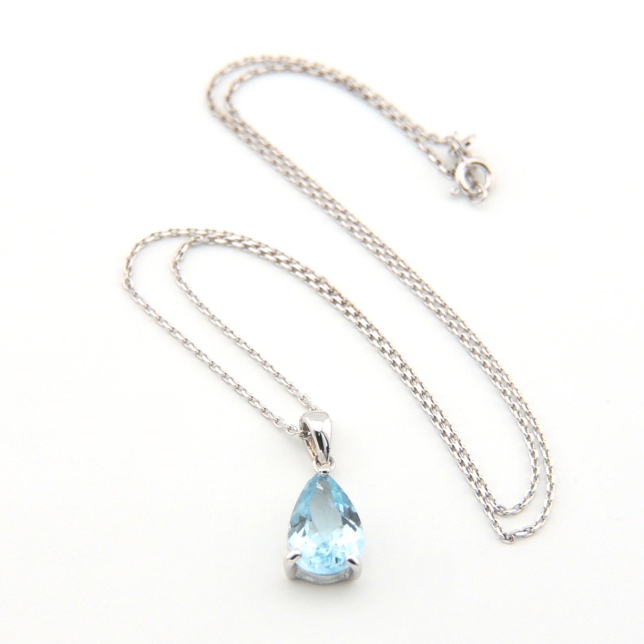 Necklace with a teardrop-shaped blue gemstone pendant on a white background